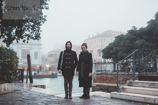 Porträt eines Ehepaares am nebligen Kanal stehend  Venedig  Italien