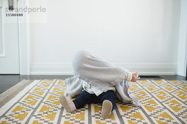 Kleines Mädchen versteckt sich unter einer Decke