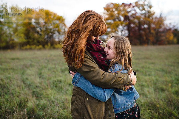 Mutter und Tochter umarmen sich auf einer Wiese  Lakefield  Ontario  Kanada
