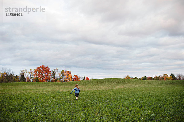 Junges Mädchen läuft im offenen Feld  Lakefield  Ontario  Kanada