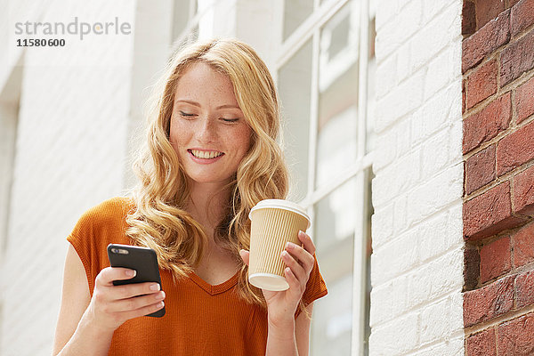 Frau bei Kaffee und SMS in der Straße  London  UK