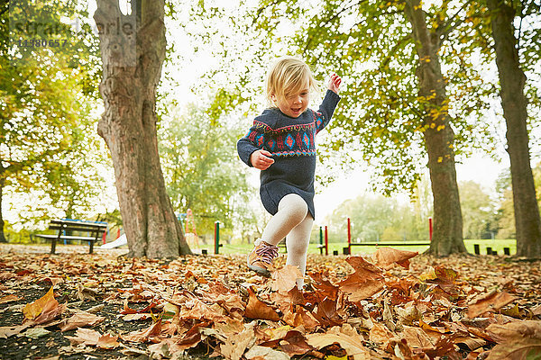 Mädchen spielt im Herbstlaub