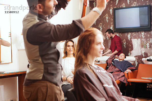 Weibliche Kunden  die ihr Haar im Friseursalon stylen lassen
