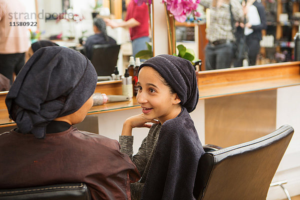 Mädchen und Mutter mit Handtüchern auf den Köpfen im Friseursalon