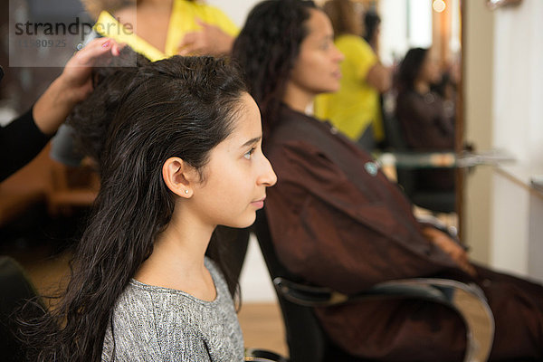 Mädchen und Mutter mit Frisur im Friseursalon