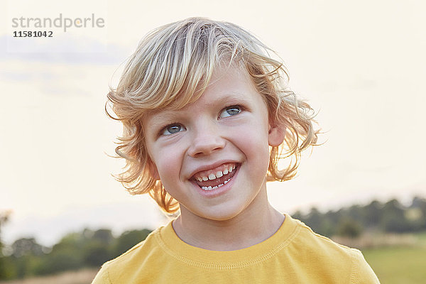 Porträt eines blondhaarigen  blauäugigen Jungen auf dem Spielfeld