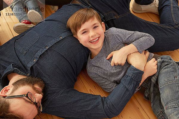Portrait eines auf dem Boden spielenden Jungen und Vaters