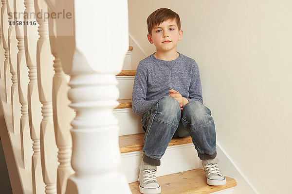 Porträt eines auf einer Treppe sitzenden Jungen