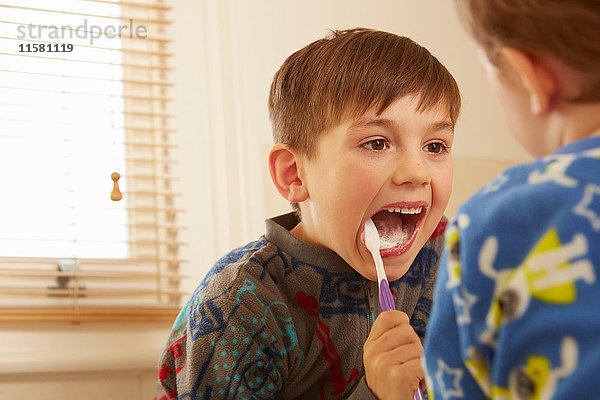 Über-Schulter-Ansicht eines Jungen und eines Bruders beim Zähneputzen im Badezimmer
