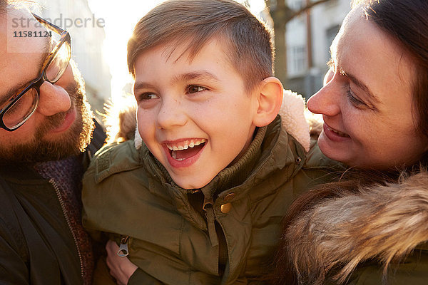 Lächelnder Junge zwischen erwachsenen Eltern