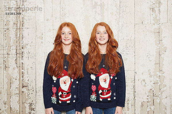 Porträt von Zwillingsschwestern in Weihnachtspullovern