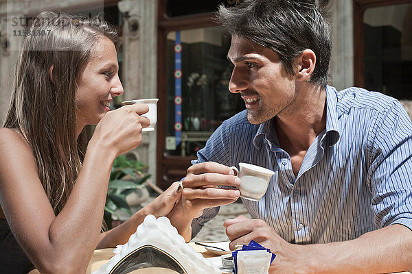 Junges Paar sitzt vor einem Café und trinkt Kaffee  Turin  Piemont  Italien