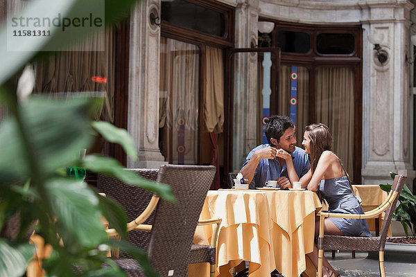 Junges Paar sitzt vor einem Café  Turin  Piemont  Italien