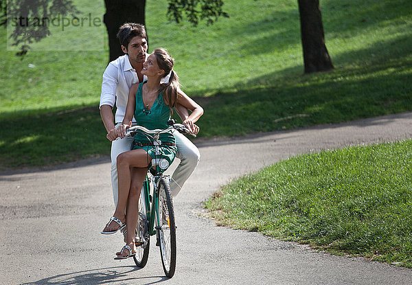 Junges Paar fährt mit dem Fahrrad durch den Park  Turin  Piemont  Italien