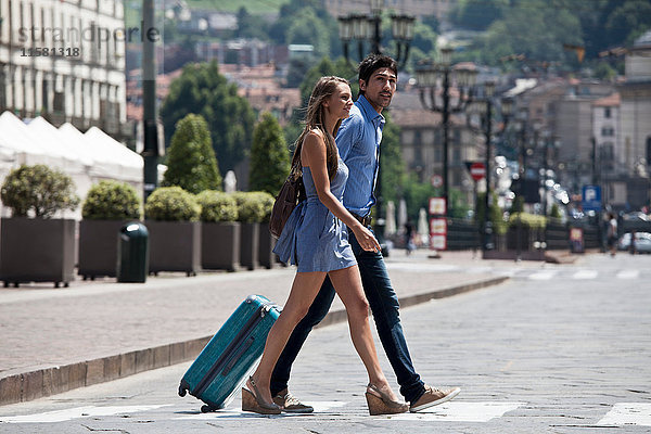 Junges Paar überquert Straße  zieht Koffer  Turin  Piemont  Italien