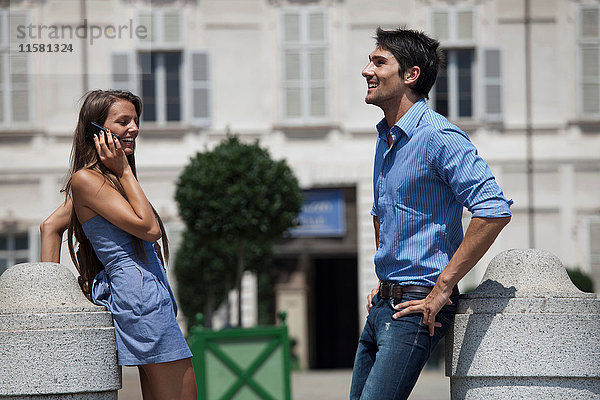 Junges Paar steht im Freien  junge Frau benutzt Smartphone  Turin  Piemont  Italien