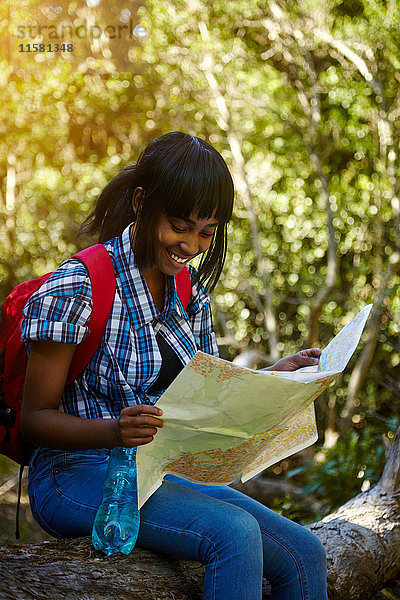 Junge Frau sitzt auf einem Felsen und schaut auf die Karte  Kapstadt  Südafrika