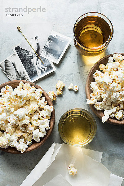 Stilleben aus Popcorn und Getränken  neben alten Schwarz-Weiß-Fotografien  Draufsicht