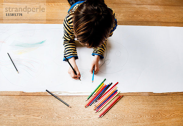 Draufsicht eines auf dem Boden liegenden Jungen Zeichnung auf langem Papier