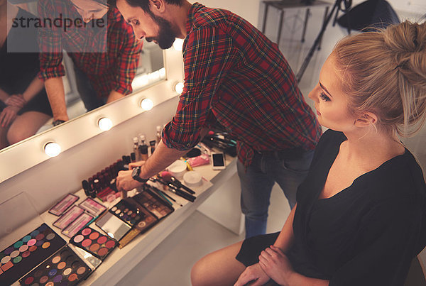 Männlicher Make-up-Künstler wählt Make-up für Fotoshooting