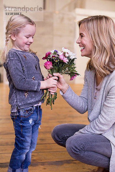 Junges Mädchen schenkt Mutter Blumenstrauss