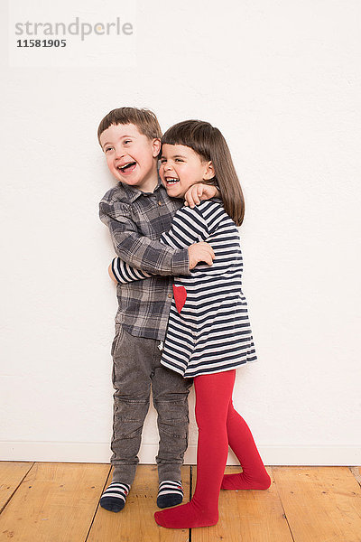 Porträt eines jungen Mädchens und Jungen  die sich umarmen und lachen