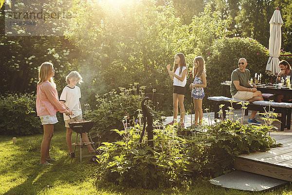 Menschen genießen den Sommer bei einer Gartenparty an einem sonnigen Tag.