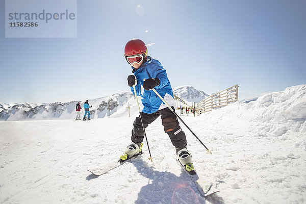 Volle Länge des Jungenskilaufs auf schneebedecktem Feld gegen klaren Himmel