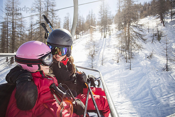 Glückliche Mutter und Tochter reisen im Skilift