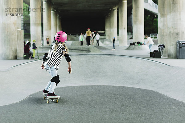 Rückansicht von Girl Skateboarding im Park