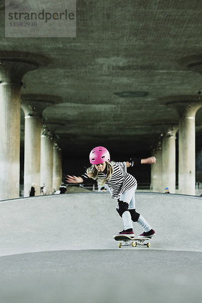 Volle Länge selbstbewusstes Girl-Skateboarden gegen Säulen im Park