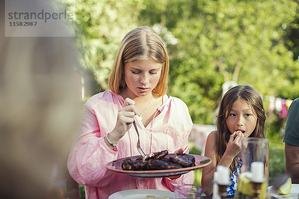 Mädchen beim Mittagessen im Garten während der Gartenparty