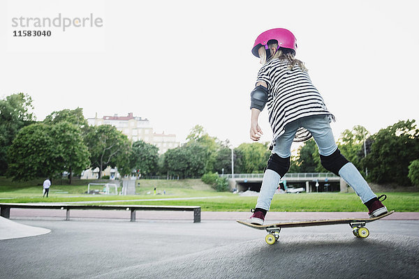 Volle Länge des Mädchens Skateboarding im Park gegen den klaren Himmel