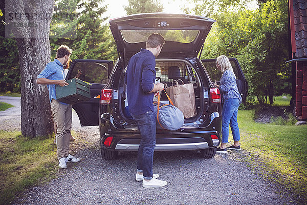 Freunde beim Verladen des Gepäcks im Auto auf der Straße