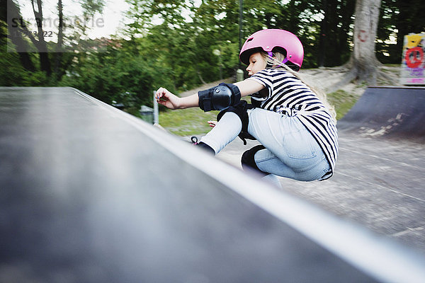 Skateboarding für Mädchen auf der Rampe im Park