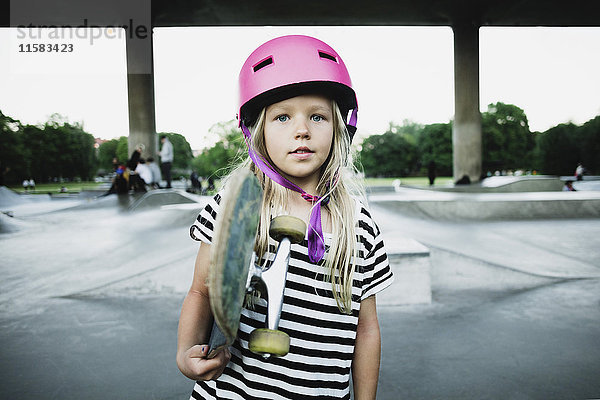 Porträt eines Mädchens mit Skateboard im Park