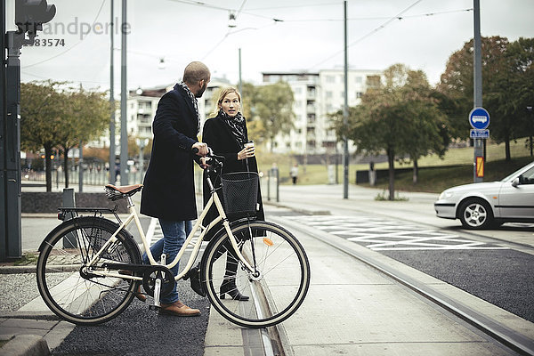 Geschäftsleute mit Fahrrad über die Stadtstraße