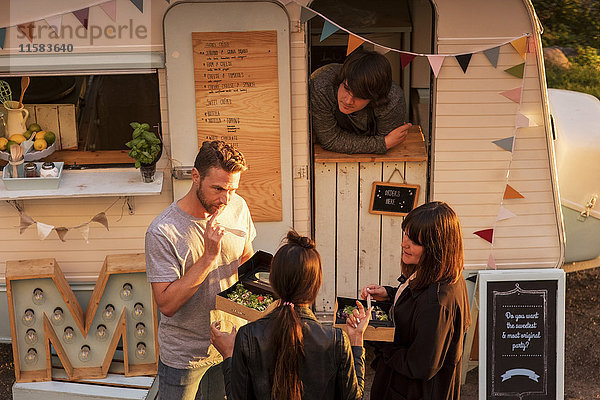 Hochwinkelansicht des männlichen Food-Truck-Besitzers mit Blick auf die Kunden auf der Straße