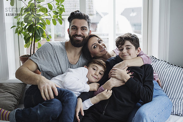 Porträt einer glücklichen Familie auf dem Sofa im heimischen Wohnzimmer