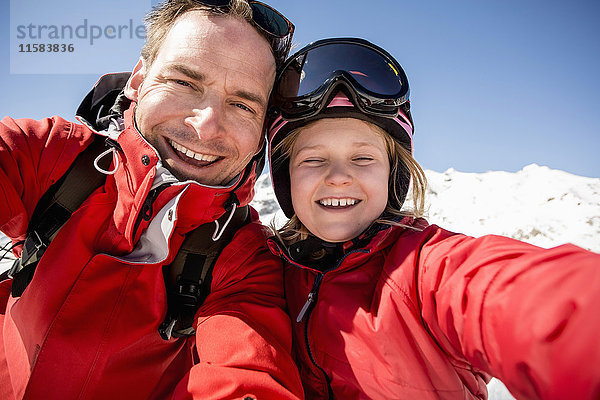 Porträt des fröhlichen Vaters und der Tochter in warmer Kleidung