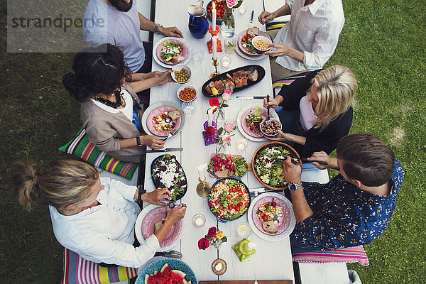 Hochwinkelansicht von multiethnischen Freunden beim Essen auf der Gartenparty