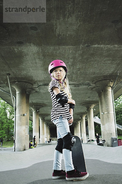 Volle Länge des Mädchens mit Skateboard im Park