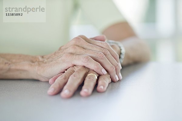 Ältere Frau mit einer Hand auf der anderen  Nahaufnahme.