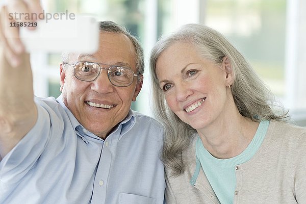 Porträt eines älteren Paares  das ein Selfie mit dem Telefon macht.