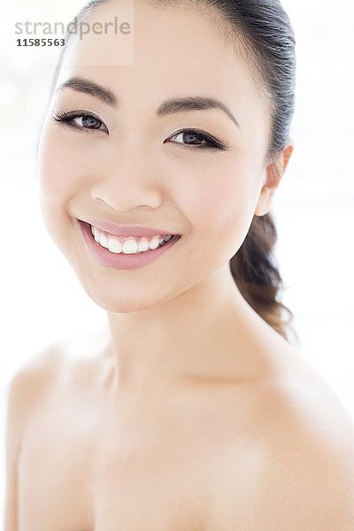 MODELL FREIGEGEBEN. Junge asiatische Frau lächelt in Richtung Kamera  Porträt.