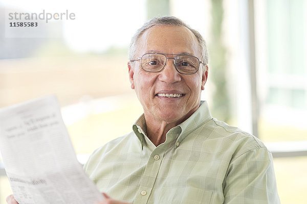 Älterer Mann liest Zeitung.