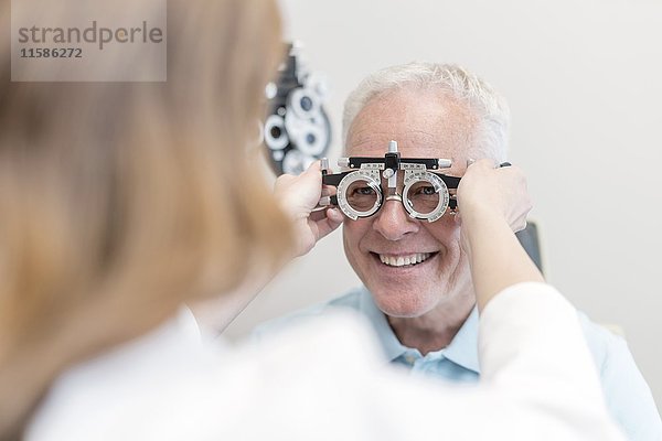 Optiker testet die Sehkraft eines Mannes.