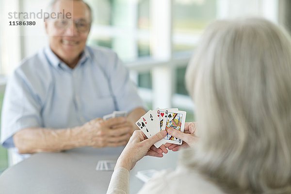 Ein älteres Paar spielt Karten.