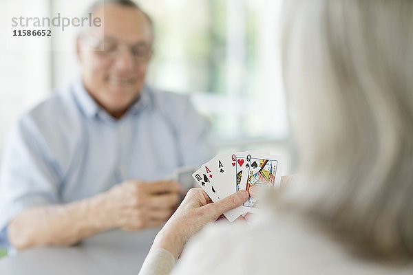 Ein älteres Paar spielt Karten.