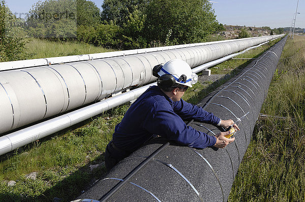 MODELL FREIGEGEBEN. Arbeiter  der eine Gasleitung überprüft.